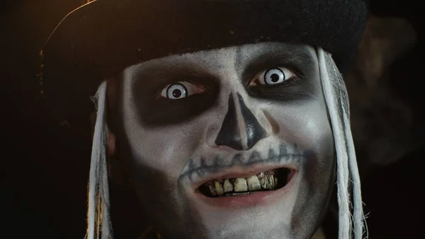 Mann mit Skelett gruselig geschminkt versucht zu erschrecken, öffnet seinen Mund und zeigt schmutzige schwarze Zähne — Stockfoto