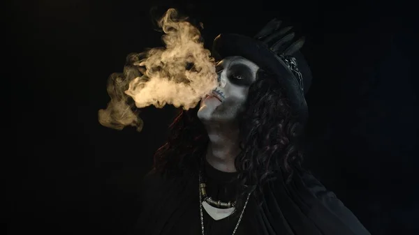 プロの頭蓋骨のメイクと不吉な男exhalingタバコ煙から彼の口と鼻 — ストック写真