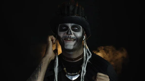 Straszny facet w kostiumie szkieletu Halloween, noszący słuchawki, słuchający muzyki, tańczący, świętujący — Zdjęcie stockowe