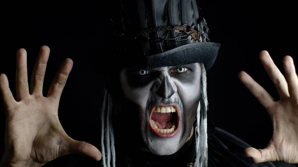 Finsterer Mann mit Halloween-Skelett-Make-up dreht den Kopf und schaut in die Kamera und versucht, Angst zu verbreiten — Stockfoto