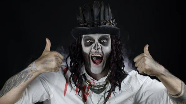 Ijesztő, mosolygós ember csontváz Halloween jelmezben, hüvelykujjal mutogató mozdulattal. Fekete háttér — Stock Fotó
