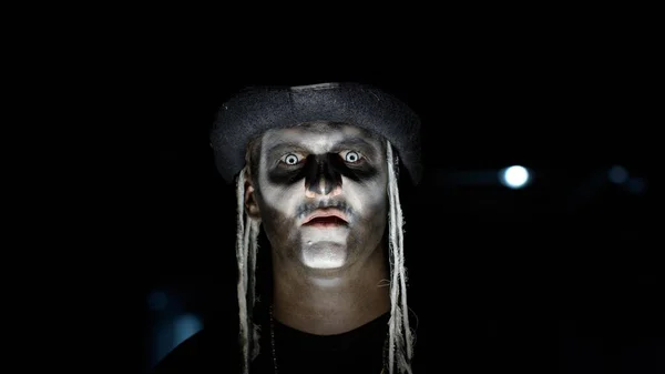 Gruseliges Männergesicht im Karnevalsschädel Halloween-Make-up aus Skelett schaut auf dem Parkplatz gruselig in die Kamera — Stockfoto
