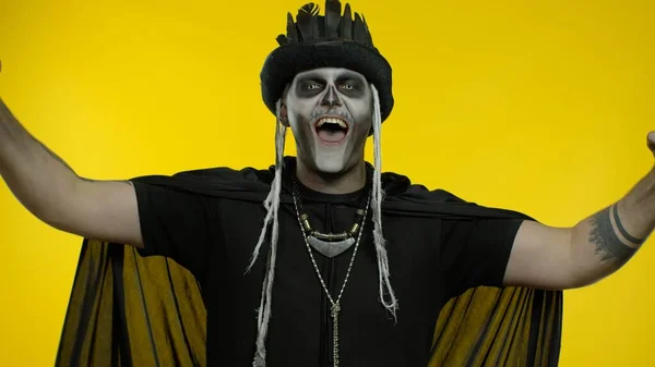 Happy creepy man with skeleton makeup celebrating win, emotionally rejoicing in victory success