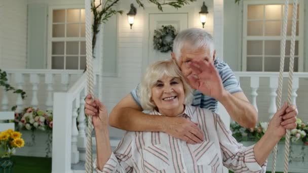 Pareja de ancianos mayores en el patio delantero en casa. Hombre abrazando a mujer. Feliz familia madura saludando las manos — Vídeos de Stock