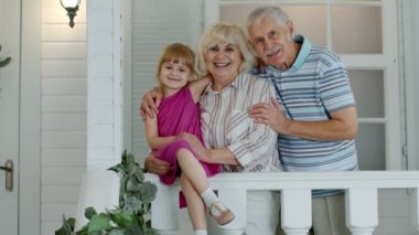 Büyükbaba ve büyükanne çiftin torunları el sallıyor, gülümsüyor ve merhaba diyorlar.