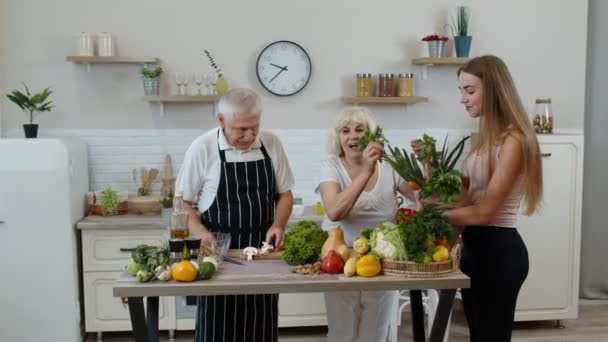 Couple âgé dans la cuisine recevant des légumes de petit-enfant. Alimentation crue saine alimentation — Video