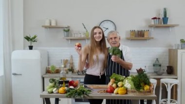 Torunu olan olgun bir adam çiğ sebze yemeği tavsiye ediyor. Dünya vegan günü konsepti