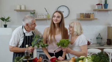 Olgun erkek ve kadının olduğu bir kız çiğ sebze yemeyi öneriyor. Sağlıklı beslenme diyeti