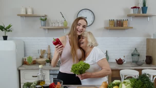 Oudere grootmoeder met kleindochter adviseert rauw groentevoedsel te eten. Plantaardige voeding — Stockvideo