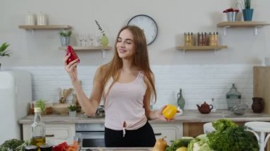 Kız çiğ sebze yemeği tavsiye ediyor. Ellerinde biber var. Kilo kaybı ve diyet konsepti