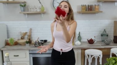 Kız çiğ sebze yemeği tavsiye ediyor. Ellerinde biber var. Kilo kaybı ve diyet konsepti