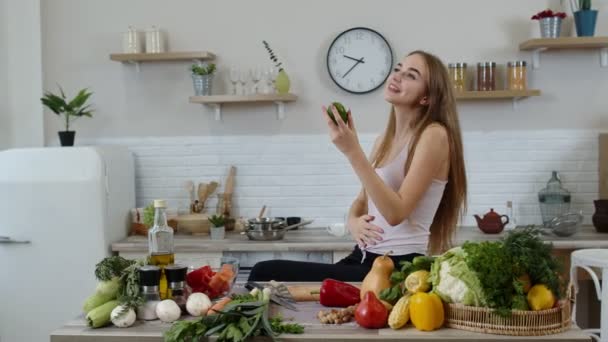 Dziewczyna poleca jedzenie surowych warzyw. Pokazuje awokado w rękach. Utrata masy ciała i koncepcja diety — Wideo stockowe