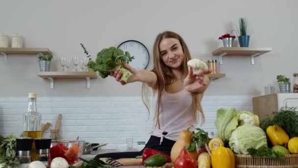 Seorang gadis merekomendasikan untuk makan sayuran mentah. Menampilkan brokoli dan kembang kol. Berat badan turun, diet — Stok Video