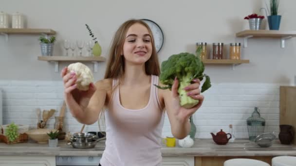 Chica recomendando comer alimentos vegetales crudos. Mostrando brócoli y coliflor. pérdida de peso, dieta — Vídeo de stock