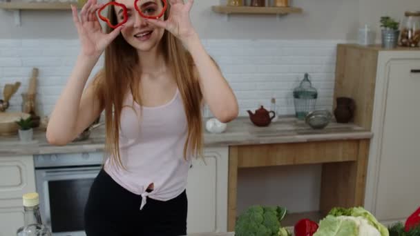 Neşeli genç kız vejetaryen dans ederken gözlerinde taze kırmızı dolmalık biber vardı. Sağlıklı beslenme — Stok video