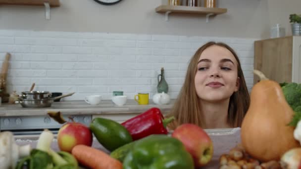 Encantadora jovencita espiando desde debajo de la mesa y agarrando manzana fresca y comiéndola. Concepto de dieta — Vídeos de Stock