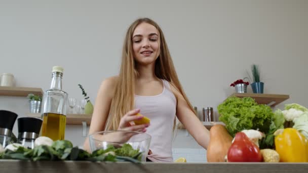 Salade de cuisine fille végétalienne avec des légumes crus, en ajoutant du jus de citron. Presser un citron dans les mains — Video