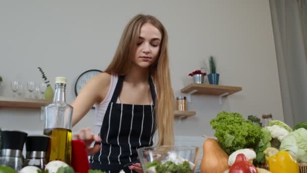 一个在网上用手机找烹饪菜谱的女人用生菜烹调沙拉 — 图库视频影像