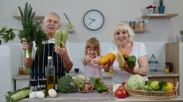 Chica con hombre maduro y mujer recomendando comer alimentos vegetales crudos. Alimentación saludable dieta — Vídeos de Stock