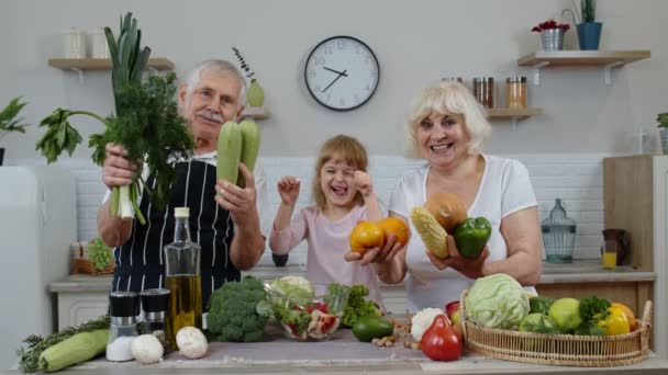 Nieta niña con abuelos mayores recomendando comer alimentos vegetales crudos. Dieta nutricional — Vídeo de stock