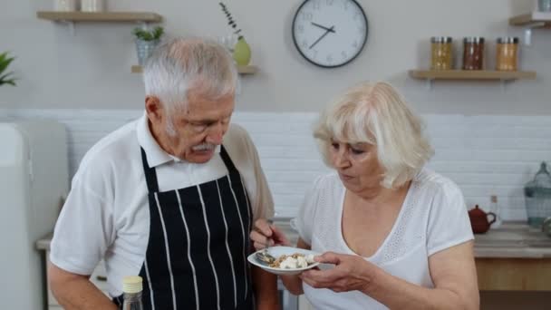 Starsza kobieta karmiąca mężczyznę surowymi kiełkami gryki z orzechami. Ekożywność jedząca dietę. Światowy Dzień Wegański — Wideo stockowe