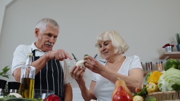 Ηλικιωμένοι παππούδες τρώνε ωμό μπρόκολο και κουνουπίδι. Χορτοφαγική δίαιτα. Υγιής οικογένεια ηλικιωμένων — Αρχείο Βίντεο