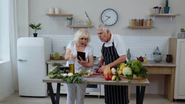 Veganistisch stel dat salade kookt met rauwe groenten. Kijken op digitale tablet voor online recept — Stockvideo