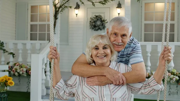 Pareja de ancianos juntos en el patio delantero en casa. Hombre balanceándose mujer durante cuarentena del Coronavirus — Foto de Stock