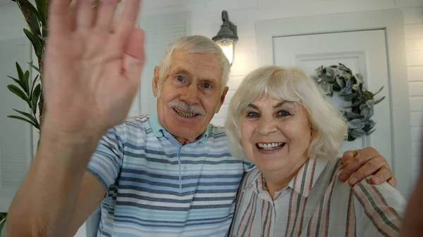 Senior pareja de ancianos caucásicos utilizando el teléfono móvil para la videollamada, haciendo selfie en el porche en casa — Foto de Stock