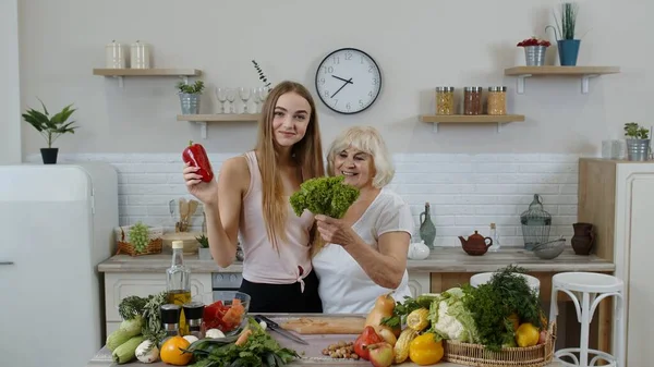 Donna matura con nipotina che consiglia di mangiare cibo vegetale crudo. Mondo vegan day concept — Foto Stock