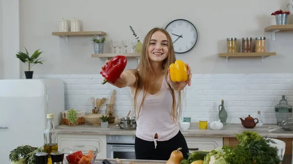 Ragazza che consiglia di mangiare cibo vegetale crudo. Mostrando peperoni in mano. Perdita di peso e dieta concetto — Foto Stock