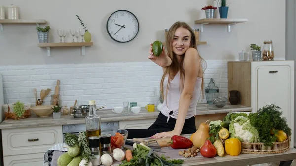 Ragazza che consiglia di mangiare cibo vegetale crudo. Mostrando avocado in mano. Perdita di peso e dieta concetto — Foto Stock