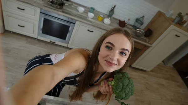 POV shot of blogger girl making photo, taking selfies with broccoli for social media on mobile phone — Stock Photo, Image