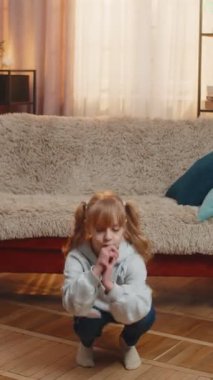 Sağlıklı bir genç kız evde durup basit çömelmeler yapıyor ve artan bir çabayla bir, iki, üç tane sayıyor. Çocuk kanepeye oturur ve kısa bir çalışmadan sonra mutlu bir şekilde kahkaha atar.