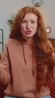 Avuç içi. Yazıklar olsun sana. Kızıl saçlı üzgün bir kadın saygısız bir jest yapıyor. Başarısız olmaktan sıkılmış olması kötü haber doğuruyor. Oturma odasında kanepede oturan kızın portresi. Yaşam Tarzları.