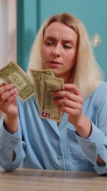 Kafkasyalı serbest çalışan genç bir kadın nakit parasız sayıyor. Finansal kriz. İflas. Yoksulluk ve yoksulluk. Kadın iş kadını oturma odasındaki ofis masasında oturuyor..