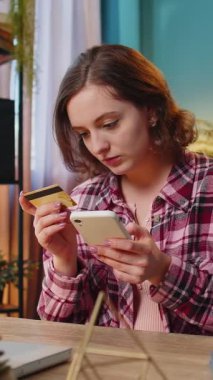 Kafkasyalı mutlu bir kadın banka kartı ve akıllı telefonu merkez ofisteki online alışveriş ödemeleri için kullanıyor. İş anlaşması. Gülümseyen kız cep telefonu E-bankacılık uygulama servisiyle serbest alım yapıyor..