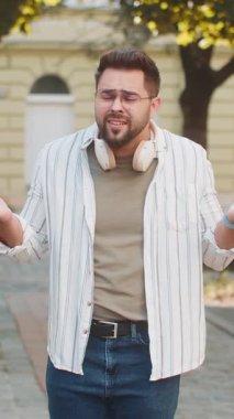 Omuzlarını silkeleyen üzgün genç bir turistin zor bir soruya tepkisi belirsiz. Şaşkın milenyum adamı şehir sokaklarında hayal kırıklığı yaşıyor.