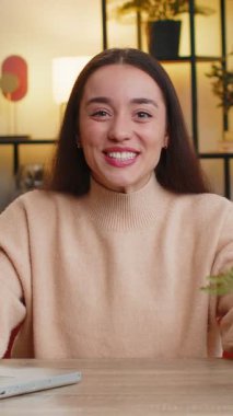 Mutlu Kafkasyalı kadın bağırarak başarıyı kutluyor gol başarısını kutluyor iyi haber piyango talihi evinde TV şampiyonluğu maçı seyrediyor. Ofisteki kız masada oturuyor.