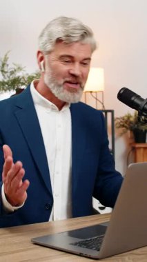 Merkez ofisteki orta yaşlı işadamı canlı jestler kullanarak podcast 'i stüdyo mikrofonuna aktarıyor. Masadaki serbest çalışan adam soruları cevaplıyor. Ses tonunu neşeli dinleyiciler canlı tutuyor..