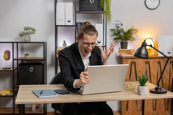 Genç, üzgün, stil sahibi bir iş adamı dizüstü bilgisayarda arama yapıyor, beklenmedik piyango sonuçlarını kaybediyor, servet kaybı, ofis masasında kötü haberler. Takım elbiseli, Kafkasyalı serbest çalışan.
