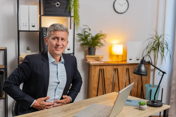 Takım elbiseli Kafkasyalı genç işadamı iş sırasında ev bilgisayarında aşırı yemek yerken hayal kırıklığına uğradı. Sinirli stil sahibi, serbest çalışan, karnına dokunan, rahatsız ve keskin bir ağrı hisseden biri..