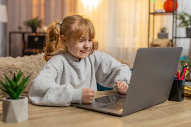 Genç bir kız dizüstü bilgisayarla masada oturuyor, evde kaybettiği bir maçtan sonra hayal kırıklığına uğruyor. Kafkasyalı çocuk üzgün bir ifadeyle hayal kırıklığı gösteriyor. Başarısızlık ve üzüntü duygularını yansıtıyor.