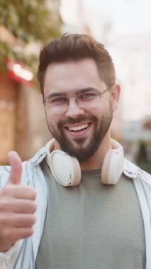 Gibi. Mutlu adam başparmağını kaldırır bir şeye katılır ya da olumlu cevap verir reklamlar iyi fikir geri bildirimlerini sever, başarı zaferini kutlar. Şehir caddesinde duran adam turist.