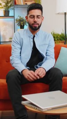 Hintli bir adam odaya girer dizüstü bilgisayarda yazmaya başlar. İnternette gezinir. Uygulamalar kanepede oturur. Evdeki bilgisayarda çalışan mutlu İspanyol genç adam. Not defterindeki e-öğrenme interneti