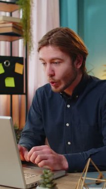 Dizüstü bilgisayar ağı üzerinde çalışan mutlu Kafkasyalı genç işadamı ani zafer, galibiyet, gol başarısı, iyi kariyer haberleri karşısında şok oldu. İş yerinde yumruklarını sıkan heyecanlı, serbest çalışan adam..