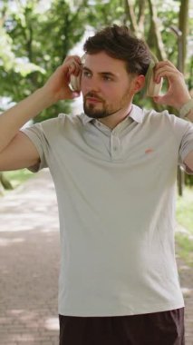 Atletik fitness sporu koşucusu maraton koşucusu, kulaklık takarak müzik dinliyor. Sabah parkta kardiyo çalışması var. Sağlıklı yaşam tarzını seven mutlu bir adam. Aktif sporcu koşucu.