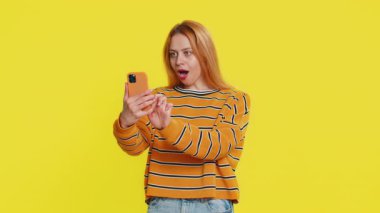 Mutlu Kafkasyalı genç kız akıllı telefon daktilo kullanıyor bağırarak evet de büyük ikramiye kazan iyi haber piyango hedefi başarıyı kutla, sarı ile oyun kazan