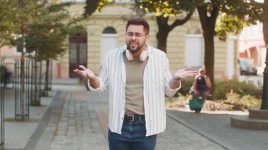 Omuzlarını silkeleyen üzgün genç bir turistin zor bir soruya tepkisi belirsiz. Şaşkın milenyum adamı şehir sokaklarında hayal kırıklığı yaşıyor.