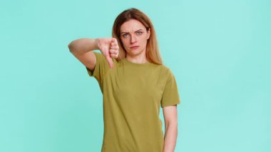 Orta yaşlı kadın onaylamadığını, memnuniyetsizlik, fikir mesajının reddedildiğini ya da sonuç verdiğini gösteren sert bir ifadeyle onaylıyor. Mavi arkaplanda izole edilmiş bir kız olumsuz tepki gösterir